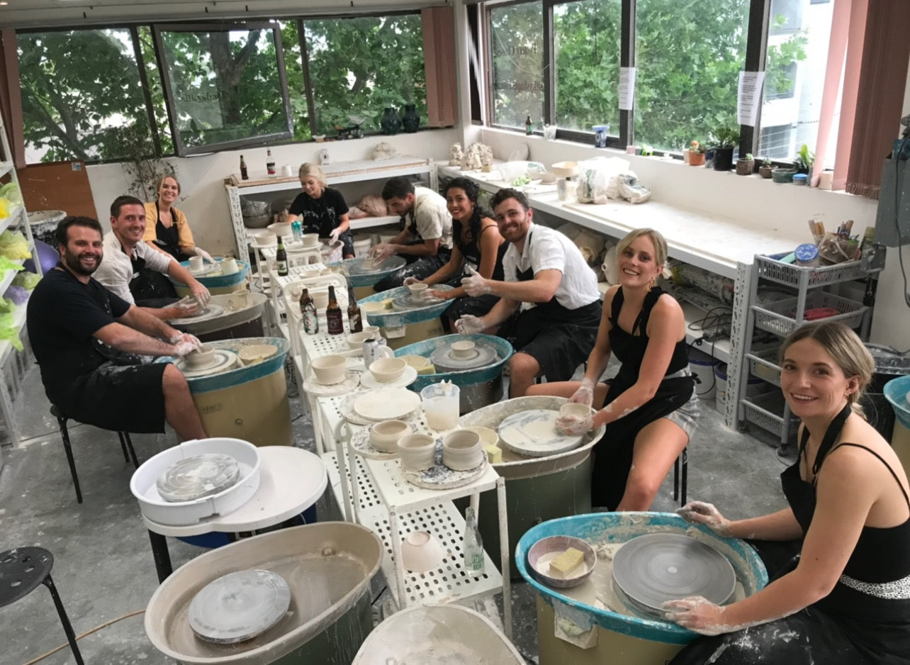 Group of people having fun on pottery wheels