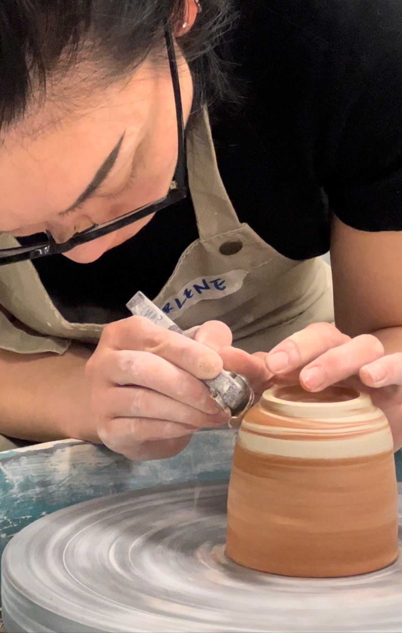 returning student shaping clay on pottery wheel at Silky Shapes Studio Sydney