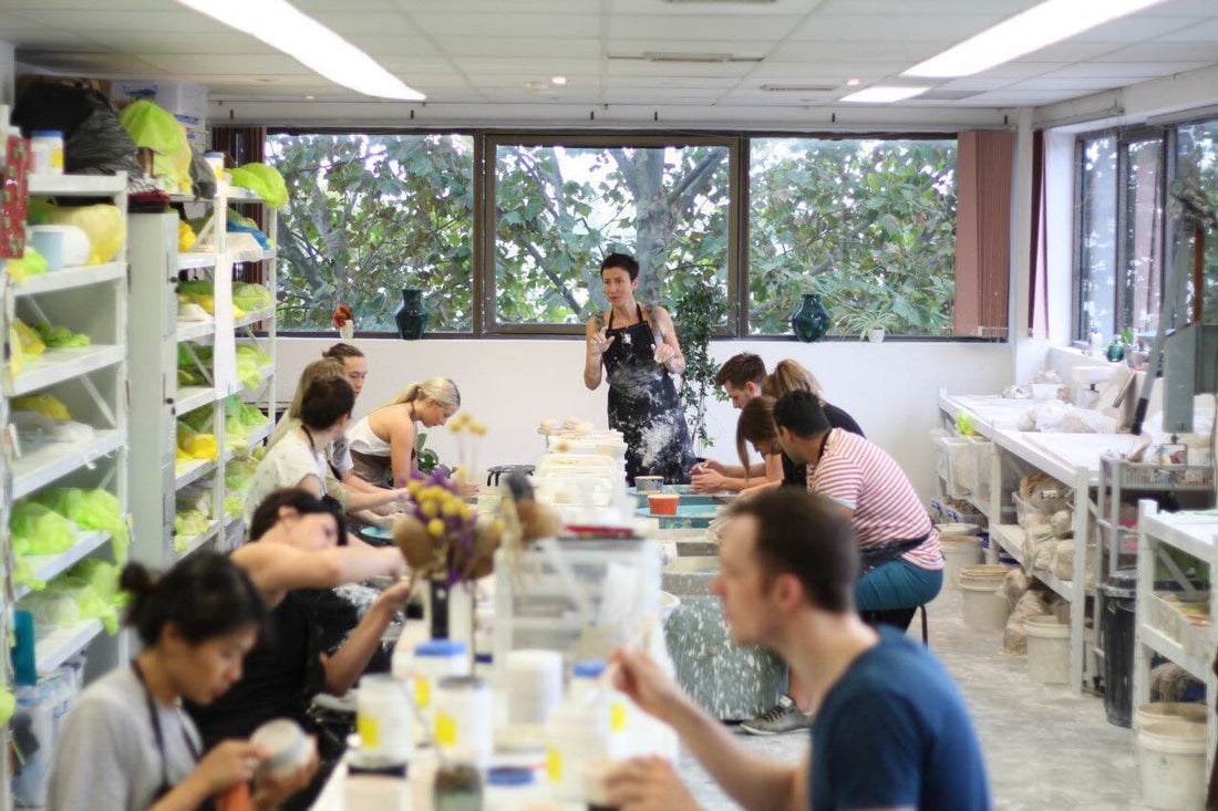 People in pottery class listening to instructions