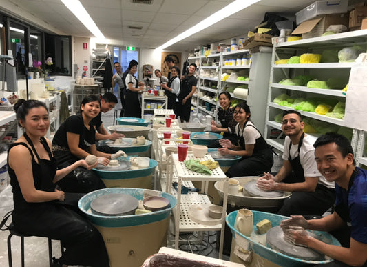 Group of people having fun on pottery wheels