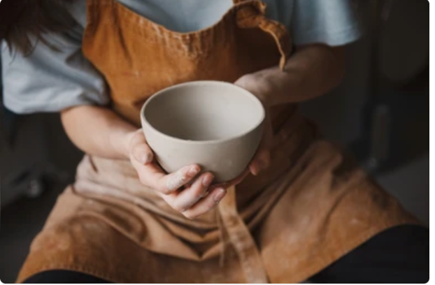 person hugging a ceramic bowl