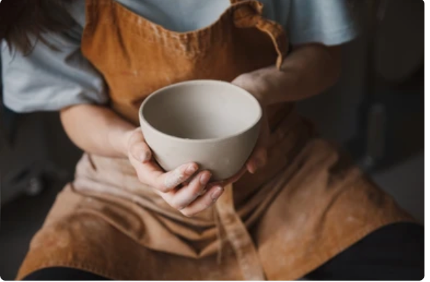 Person hugging a ceramic bowl
