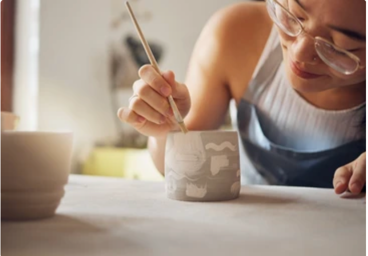 Woman glazing a ceramic piece